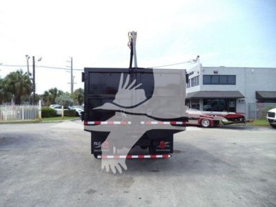 Peterbilt 337 grapple truck rear view showing crane hook and back of dump bed with reflective safety stripes.