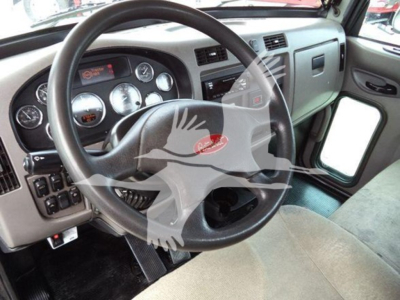 Peterbilt 337 interior showing steering wheel, dashboard gauges, and driver’s door area.