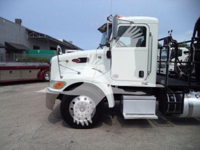 Peterbilt 337 truck side profile with white cab and grapple equipment, front wheel, and chrome steps visible.