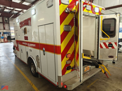 Ambulance rear/side view showing chevrolet express g4500 ambulances with high-visibility red and yellow chevrons, side compartments, rear stairs, and emergency lighting.