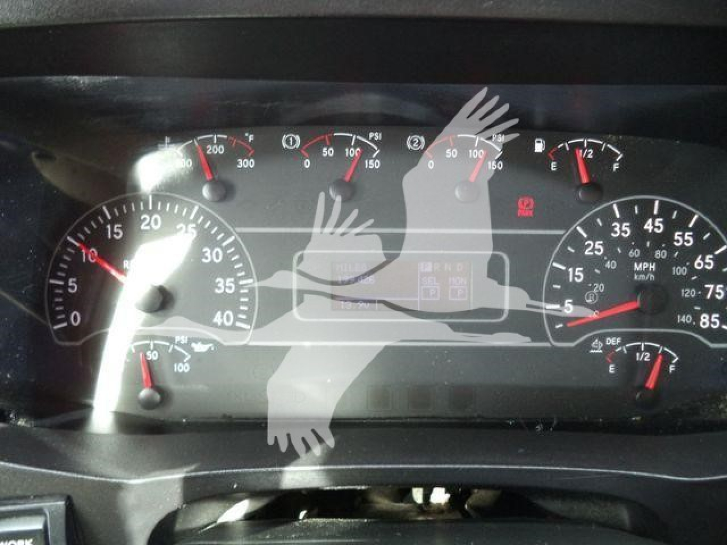 Dashboard of a 2020 International MV showing gauge clusters with speedometer, tachometer, fuel, and warning lights. The image includes a watermark overlay of hands.