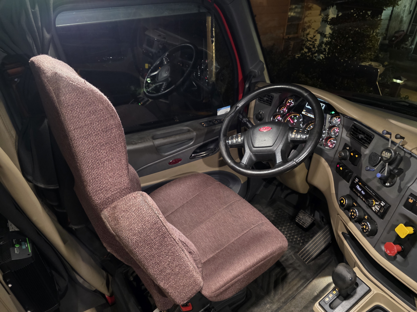 cab interior of a 2016 Peterbilt 579 showing driver seat, dashboard with steering wheel and controls, gear shifter, and instrument cluster.