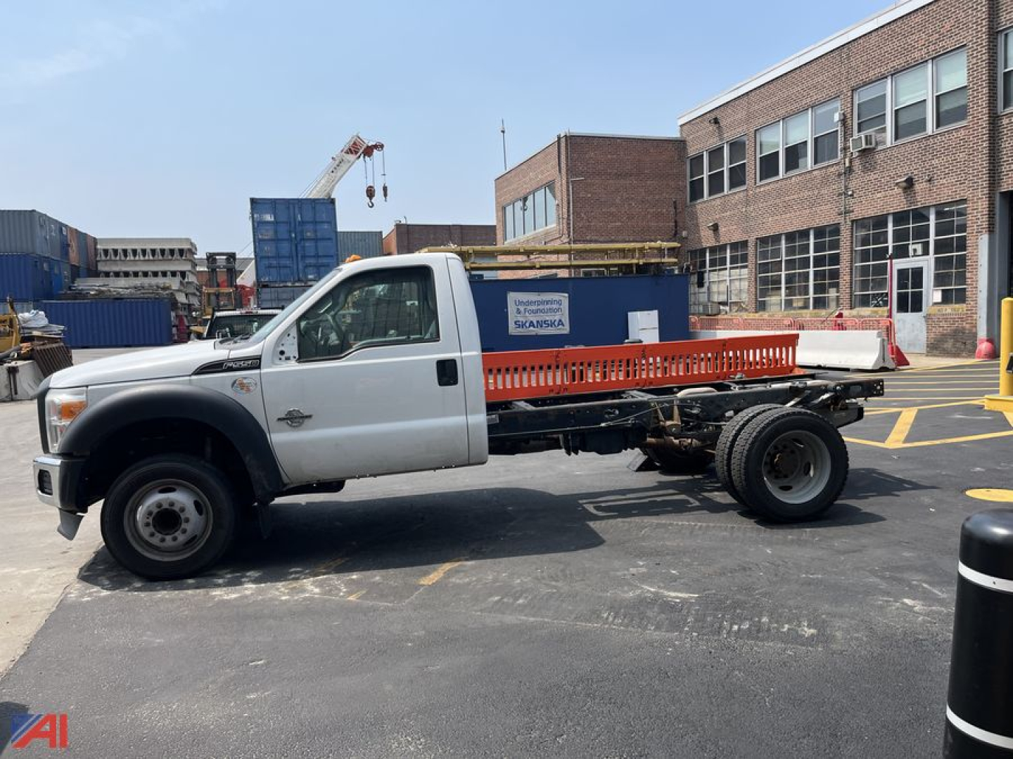 Ford F-550 cab and chassis in a parking lot with orange rail bed and F-550 badge on door showing 4x4 and large cab.