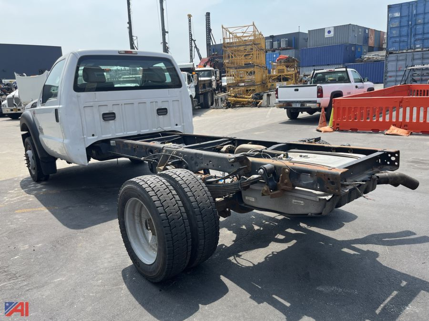 Ford F550 cab and chassis rear view showing frame, single rear dual wheel setup, exposed drivetrain, and cab with white paint.