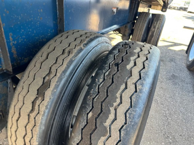 Great Dane trailer dual rear wheels showing treaded tires and undercarriage with blue trailer body