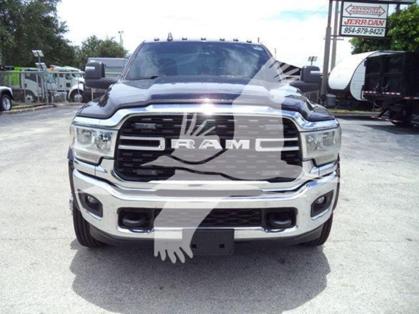 Ram 4500 front view showing RAM grille badge and chrome bumper with headlights, part of a pickup truck in a dealership lot.