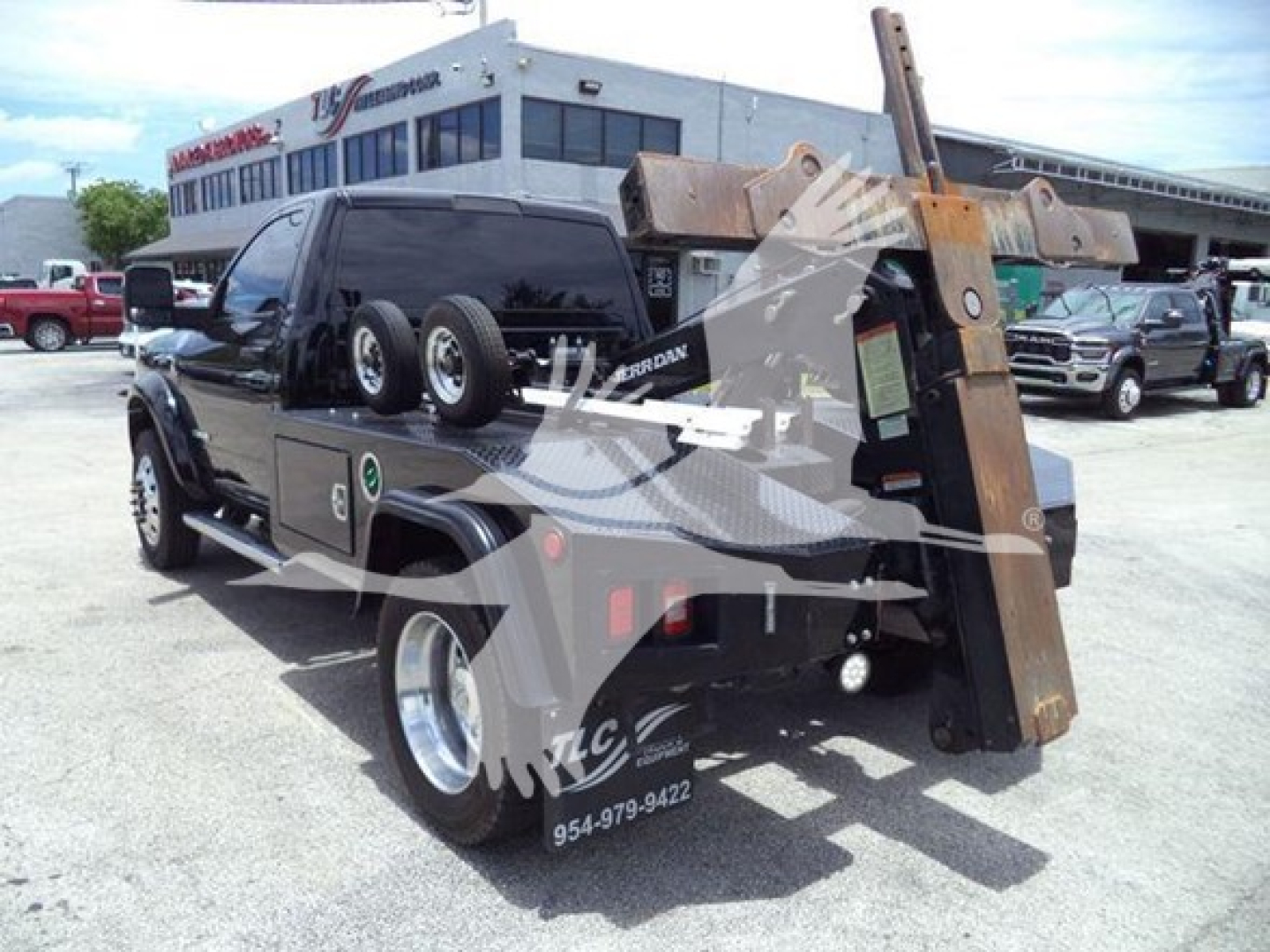 Ram 4500 SLT pickup with winch and heavy-duty tow frame on a tow truck bed showing storage boxes and components.