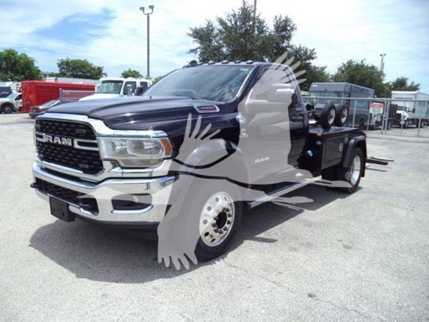 Ram 4500 pickup tow truck in a dealership lot showing front grille and extendable boom winch.