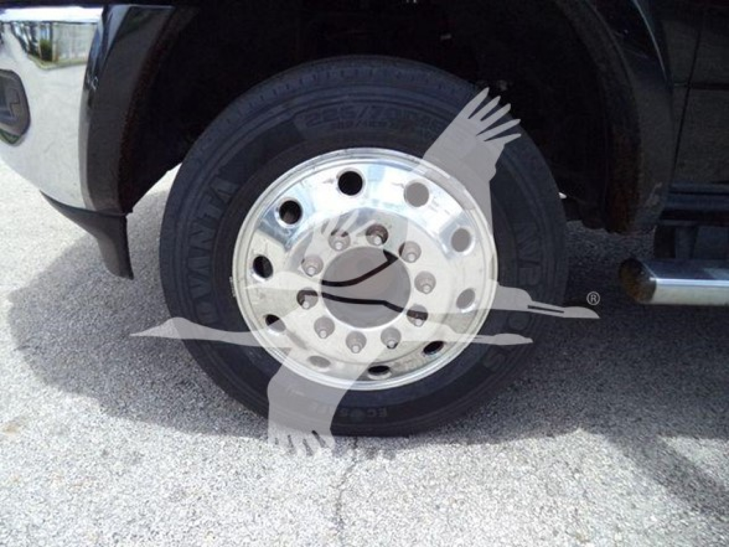 Truck wheel and chrome hubcap showing tire with visible branding and lug nuts.