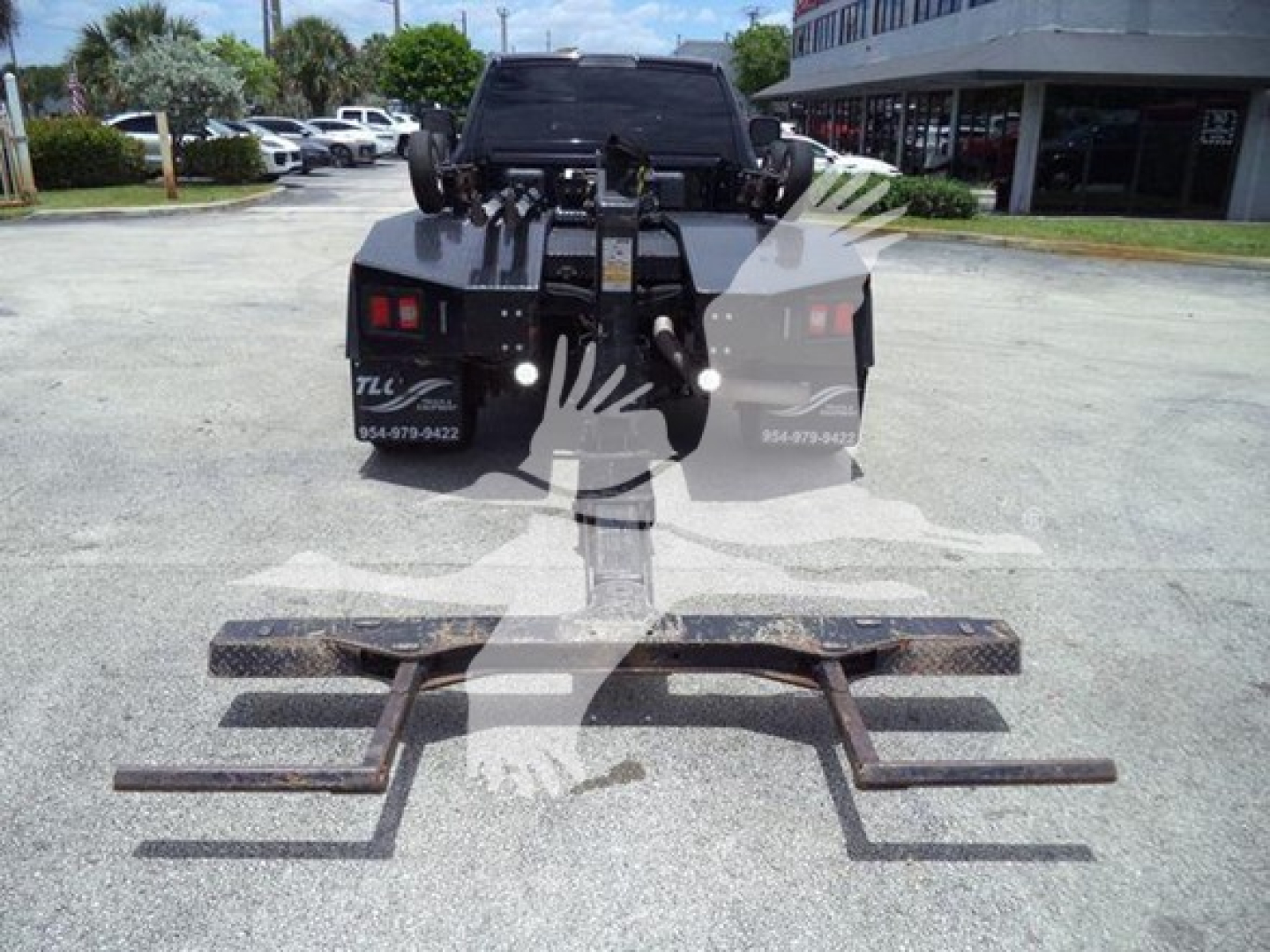Ram 4500 rear view showing winch assembly and mounting frame with multiple steel hooks and brackets, hitch area visible in background.