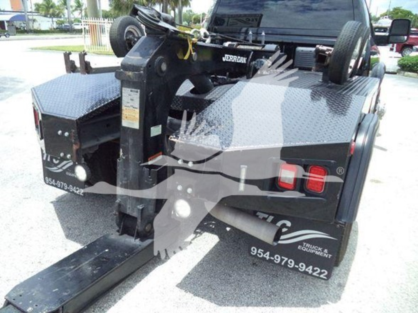 Ram 4500 truck rear with hydraulic tow winch system, aluminum diamond plate bed, mounted hitch, and dual rear lights visible.