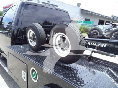 Ram 4500 SLT tow truck bed with spare wheels on a flatbed, truck cab visible, winch category vehicle.
