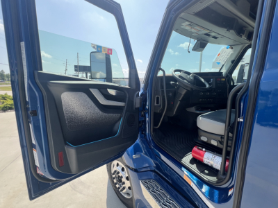 Volvo VNL64T860 interior cab door open showing driver seat and dashboard in blue truck.