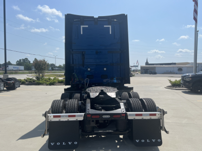 Volvo VNL64T860 tractor rear view showing dual rear axles and fifth-wheel hitch, with Volvo mud flaps and reflective rear underrun bars.