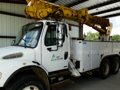 Service/utility truck showing crane equipment on Freightliner M2 106 with OPP Utilities logo on door and yellow boom crane.