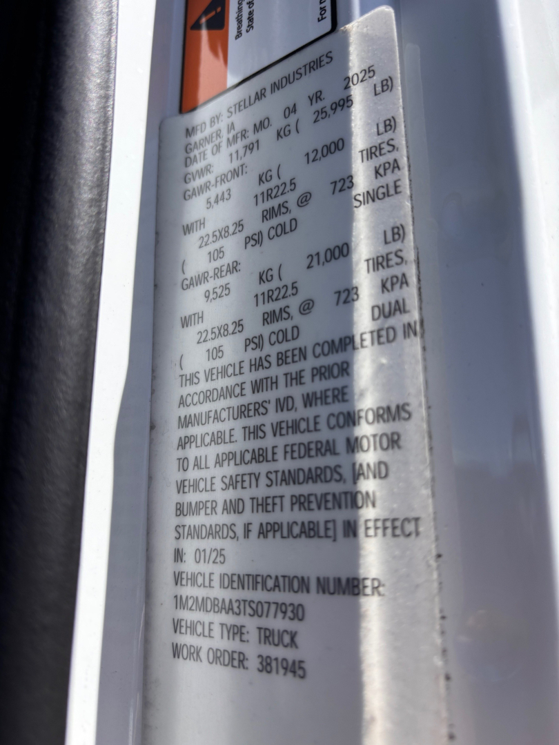 Vehicle label on a 2026 Mack MD7 showing VIN 1M2MDBAA3TS077930, serial numbers, weights, and standards. Text includes vehicle identification number and work order.