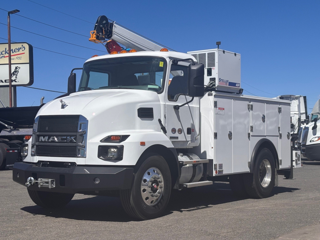 Mack MD7 service truck with utility body and crane mounted on top, front grille with 'MACK' logo, multiple compartments along the side, white color, VIN 1M2MDBAA3TS077930 visible in listing.