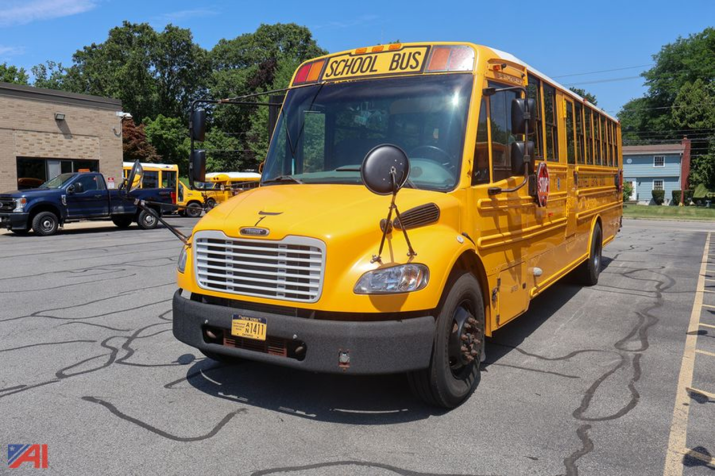 School bus showing front view with yellow body and 'SCHOOL BUS' sign on top, grille, headlights, and side mirrors.