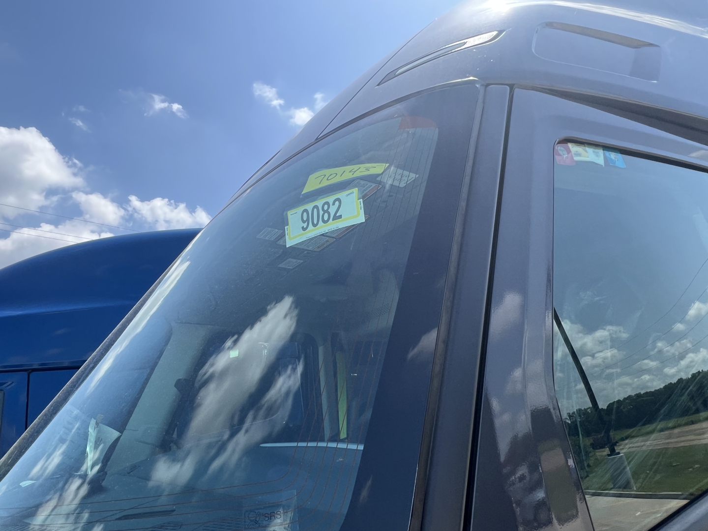 Cab exterior of a new Volvo VNL64T660 tractor showing windshield with stickers.
