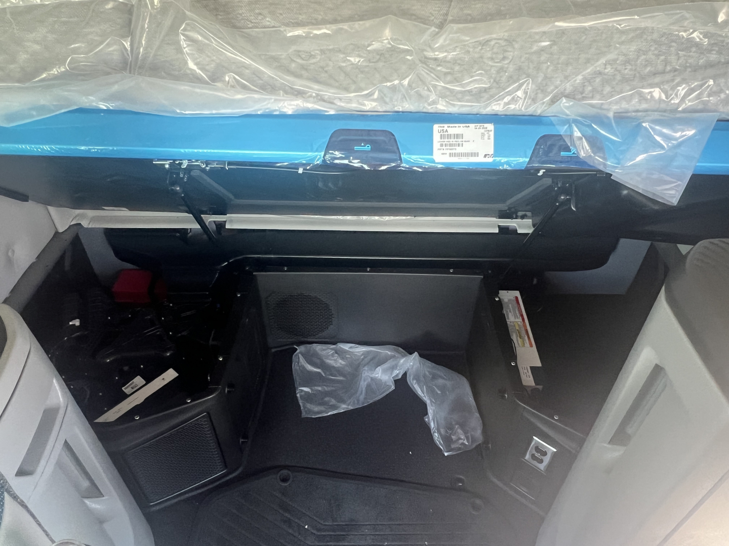 Volvo VNL64T660 cabin interior view from entry, dashboard area visible with plastic cover and exposed wiring, storage basin under dash.