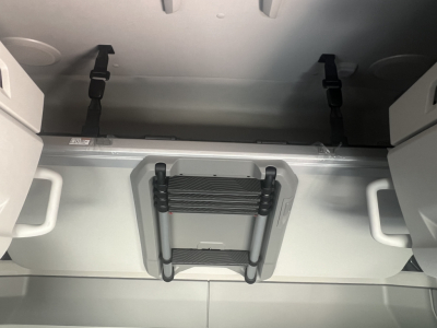 Volvo VNL64T660 sleeper cab interior showing overhead bunk area with folded ladder and tie-down straps.