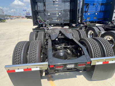 Volvo truck rear shows chassis, dual rear axles, fifth wheel, and exhaust-free area with wiring harnesses.