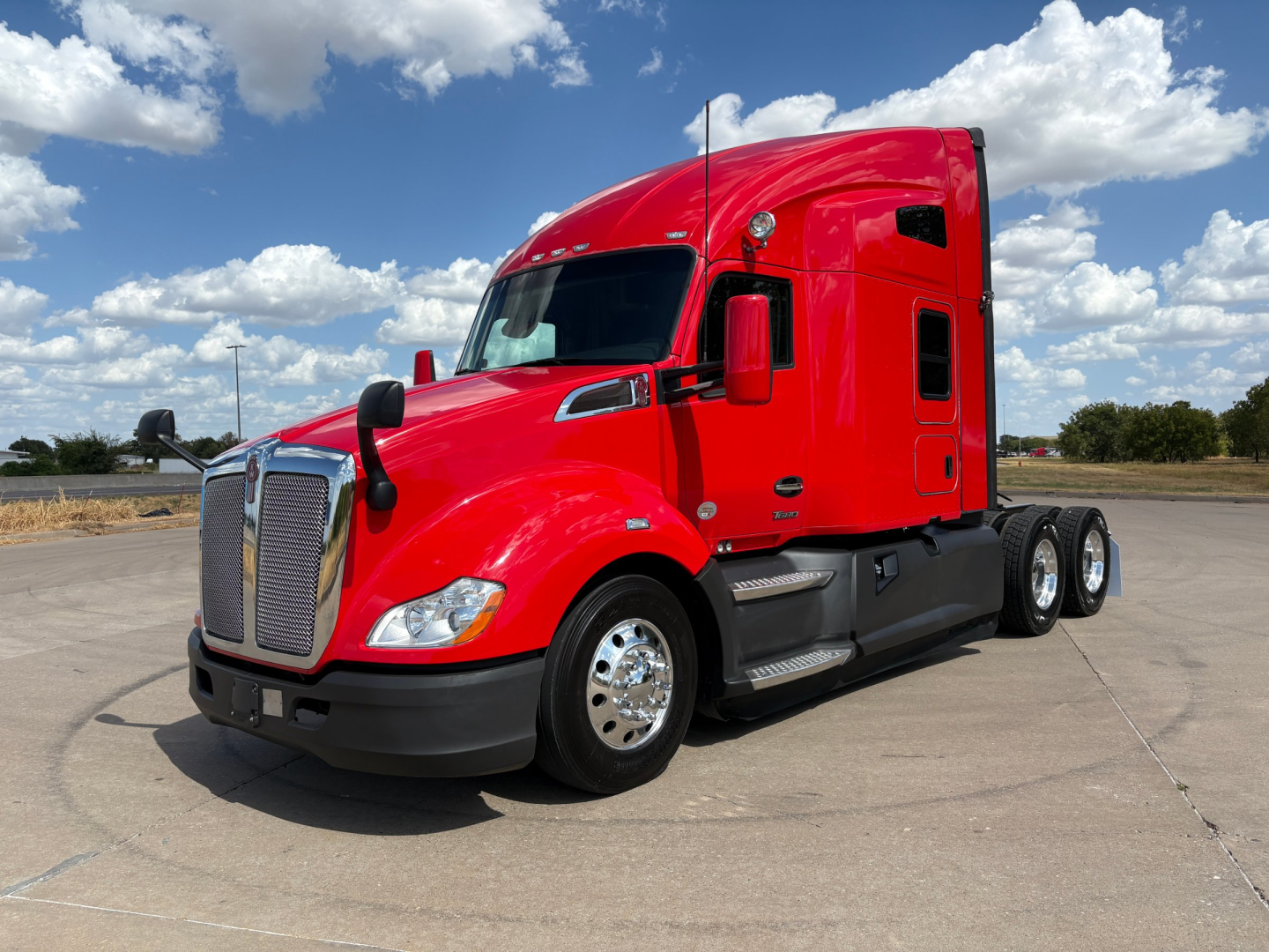 Kenworth T680 truck in red color shown from front-left angle with sleeper cab, chrome grille, and dual rear axles.