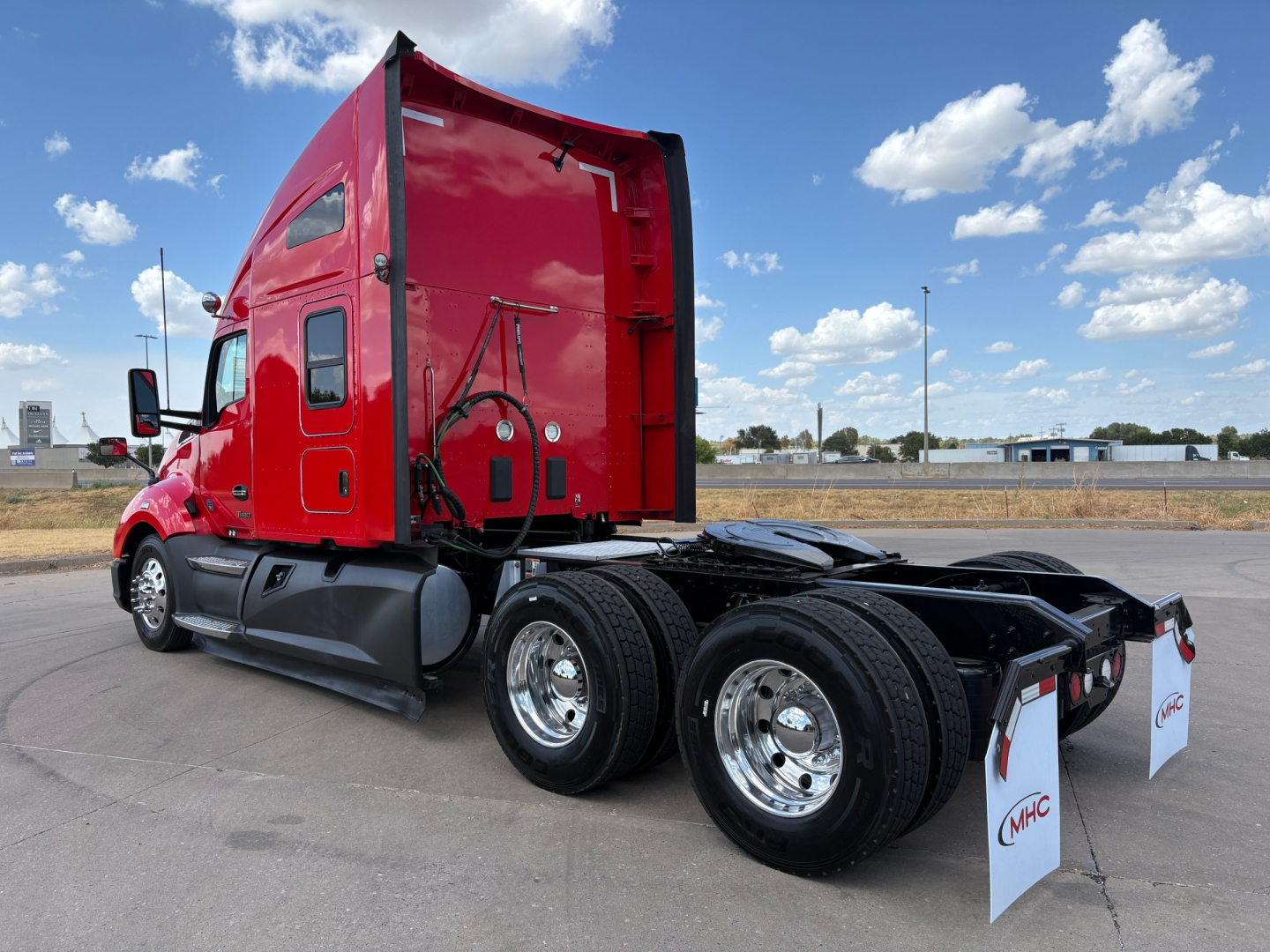 Kenworth T680 truck without trailer showing rear view and red cab with dual rear axles.