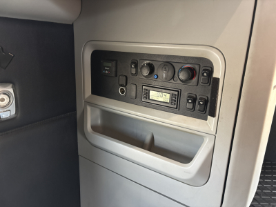 Kenworth T680 cab interior dash panel showing climate controls, radio, and utility panel with small display.