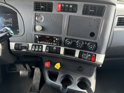 Kenworth T680 dashboard and center console showing gauges, switches, and cup holders.