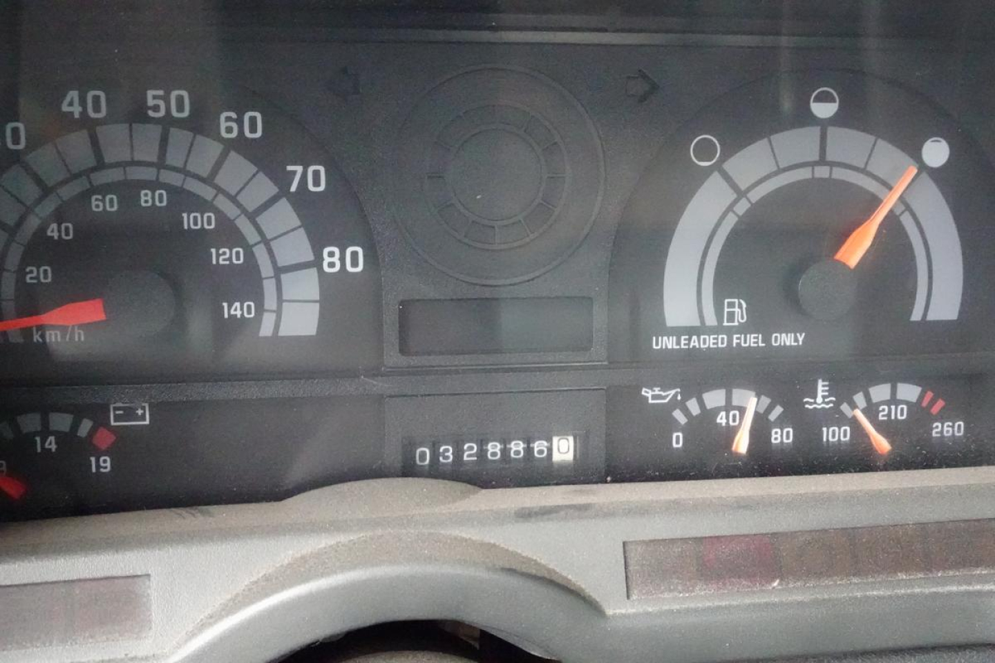 Truck dashboard cluster showing speedometer up to 80 mph and fuel gauge; odometer reading 32886 miles; tachometer and warning lights visible in instrument panel.