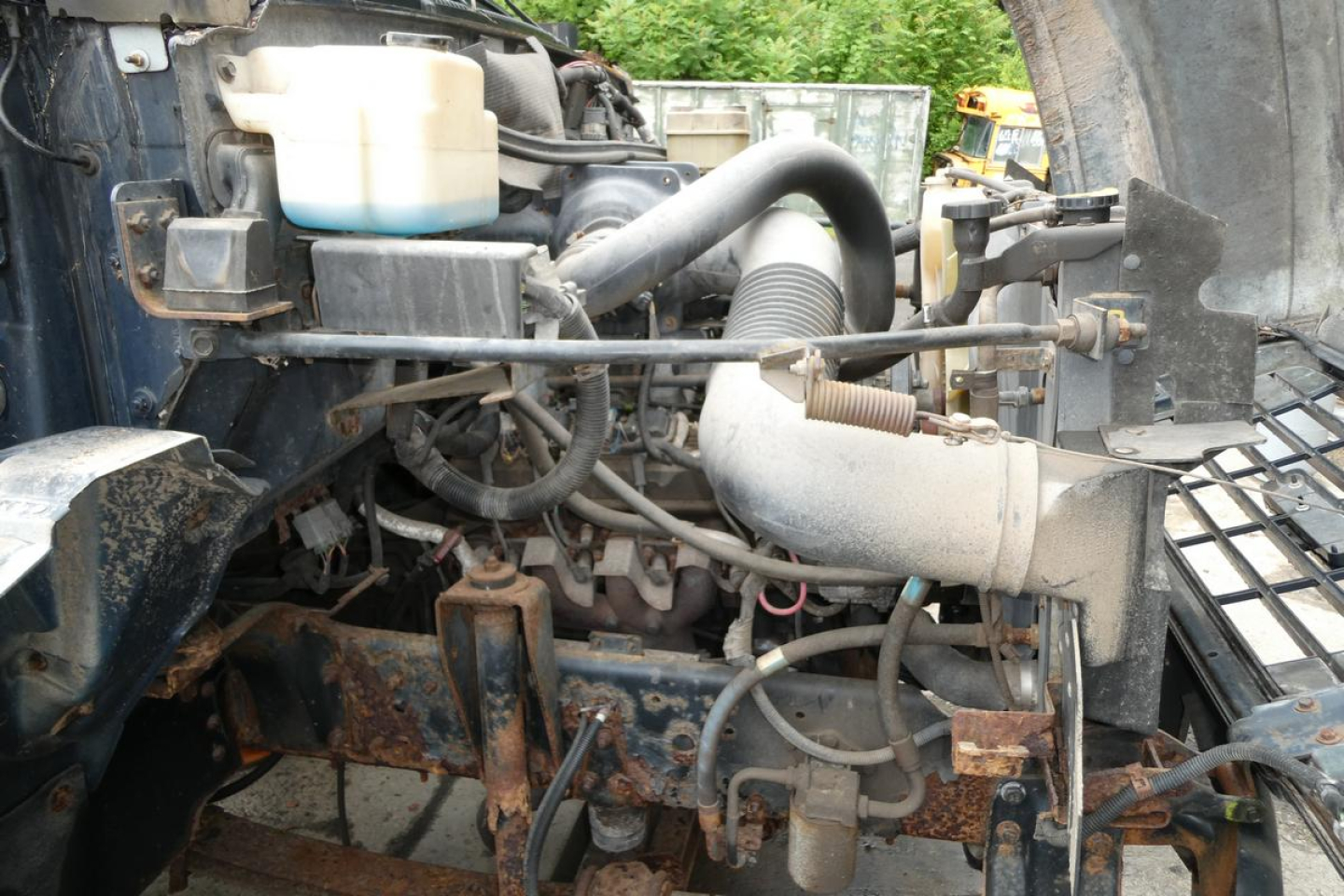 Chevrolet cab and chassis engine bay showing coolant reservoir, hoses, air intake, and various engine components.