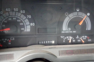 Truck dashboard cluster showing speedometer up to 80 mph and fuel gauge; odometer reading 32886 miles; tachometer and warning lights visible in instrument panel.