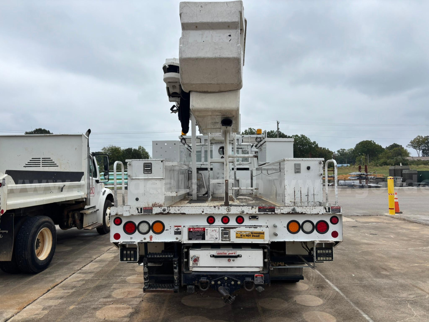 Rear view of a 2014 Freightliner M2 106 bucket truck showing rear equipment and hydraulic boom.