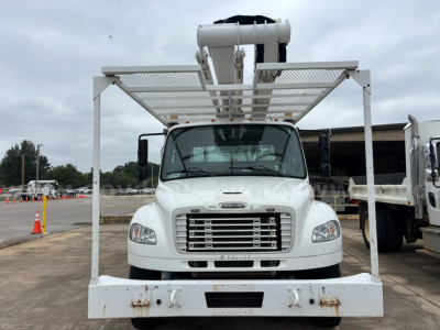 Freightliner M2 106 medium-duty bucket truck front view showing large chrome grille and white steel platform above cab for bucket lift.