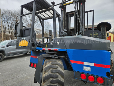 Mack CV713 Granite forklift/truck showing rear and left side with blue body panels and large tires, hydraulic masts and roll cage.