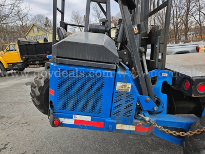 Blue Mack CV713 Granite equipment trailer/loader showing rear side with label and safety chain.