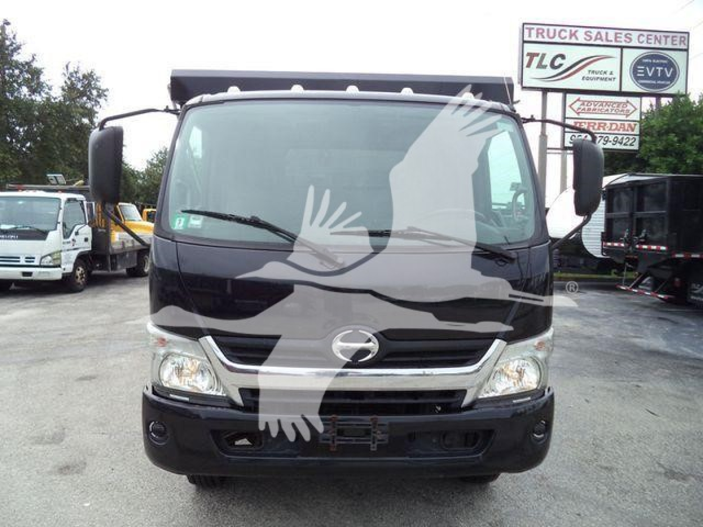 Front view of a 2019 Hino 195 roll-off truck showing the cab with Hino emblem, large windshield, and headlights.