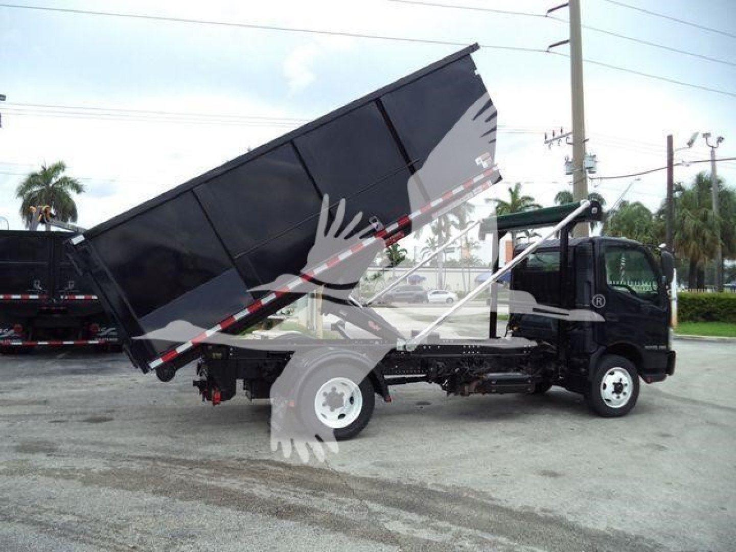 2019 Hino 195 roll-off truck side view showing hydraulic dump bed in raised position and cab with wheel.