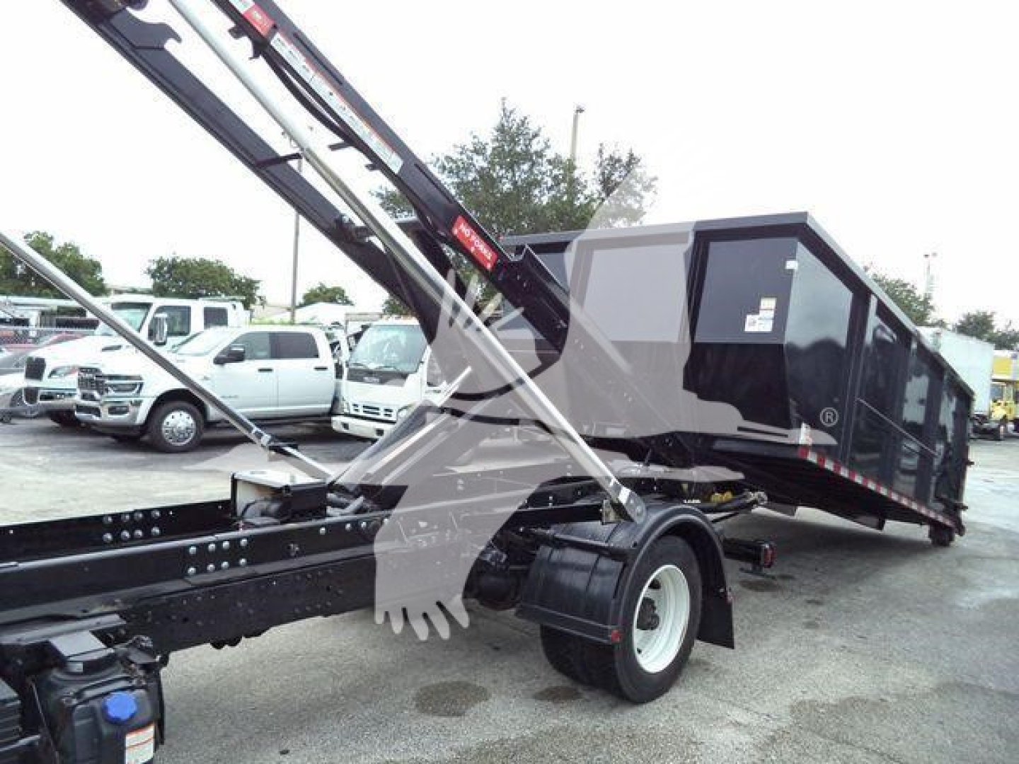 2019 Hino 195 rolloff truck showing hydraulic crane and cargo bed, side view with white wheels