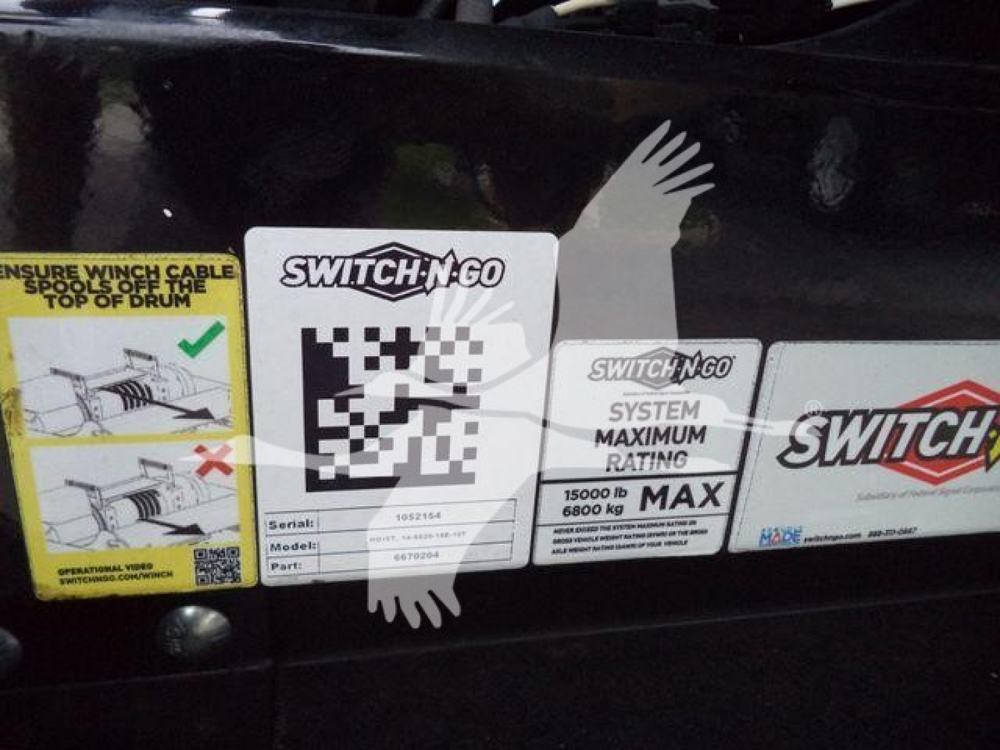 Trucks side with stickers: SWITCH-N-GO system label showing Serial 90215?; Model 4?; Part 1?; Maximum rating 15000 lb / 6800 kg. Also warning label and a graphic.