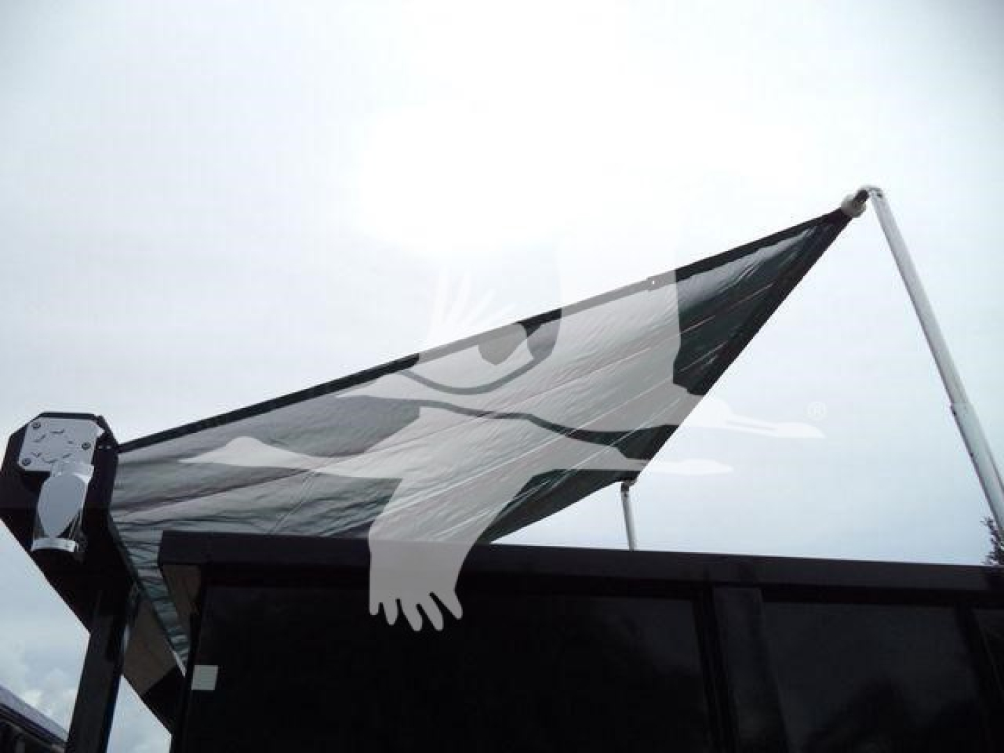 Rolloff truck bed with black-and-white flag/graphic covering rear area; no legible text visible on the vehicle itself.
