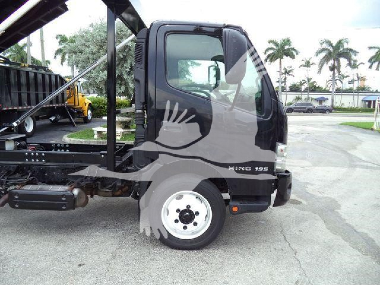 Hino 195 roll-off truck side view showing cab and wheel with model badge F10 195 on door.