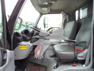 Cab interior of a 2019 Hino 195 roll-off truck showing driver seat and front dashboard with steering wheel and open door.