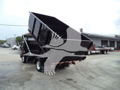 Truck dump bed in raised position on a 2019 Hino 195 roll-off truck showing raised cargo bed with hydraulic mechanism and dual rear tires.
