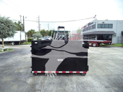 Rear view of a black roll-off truck bed on a 2019 Hino 195 with a reflective safety tape and gray camouflage on the bed.