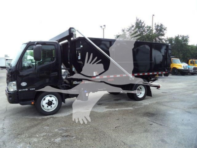 2019 Hino 195 roll-off truck side view showing cargo bed and hydraulic lifting mechanism with black cab and dark dump body.