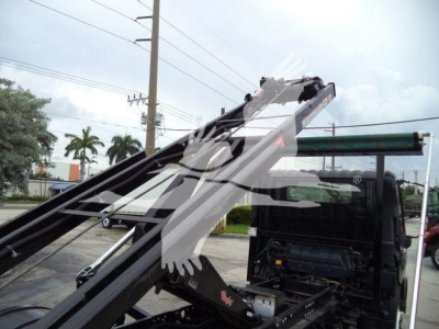 Truck cab and hydraulic arm of a roll-off truck with a watermark overlay; visible components include the truck chassis and lifting arms.