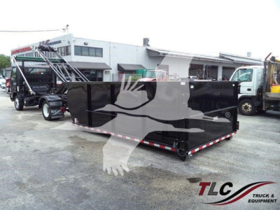 Truck with black roll-off container in yard showing Hino 195 bumper and nearby equipment.