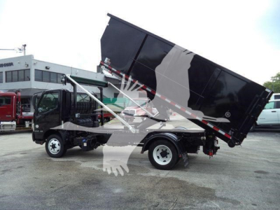 Truck chassis with raised dumping bed on a Hino 195 roll-off truck showing hydraulic lift and cargo bed.
